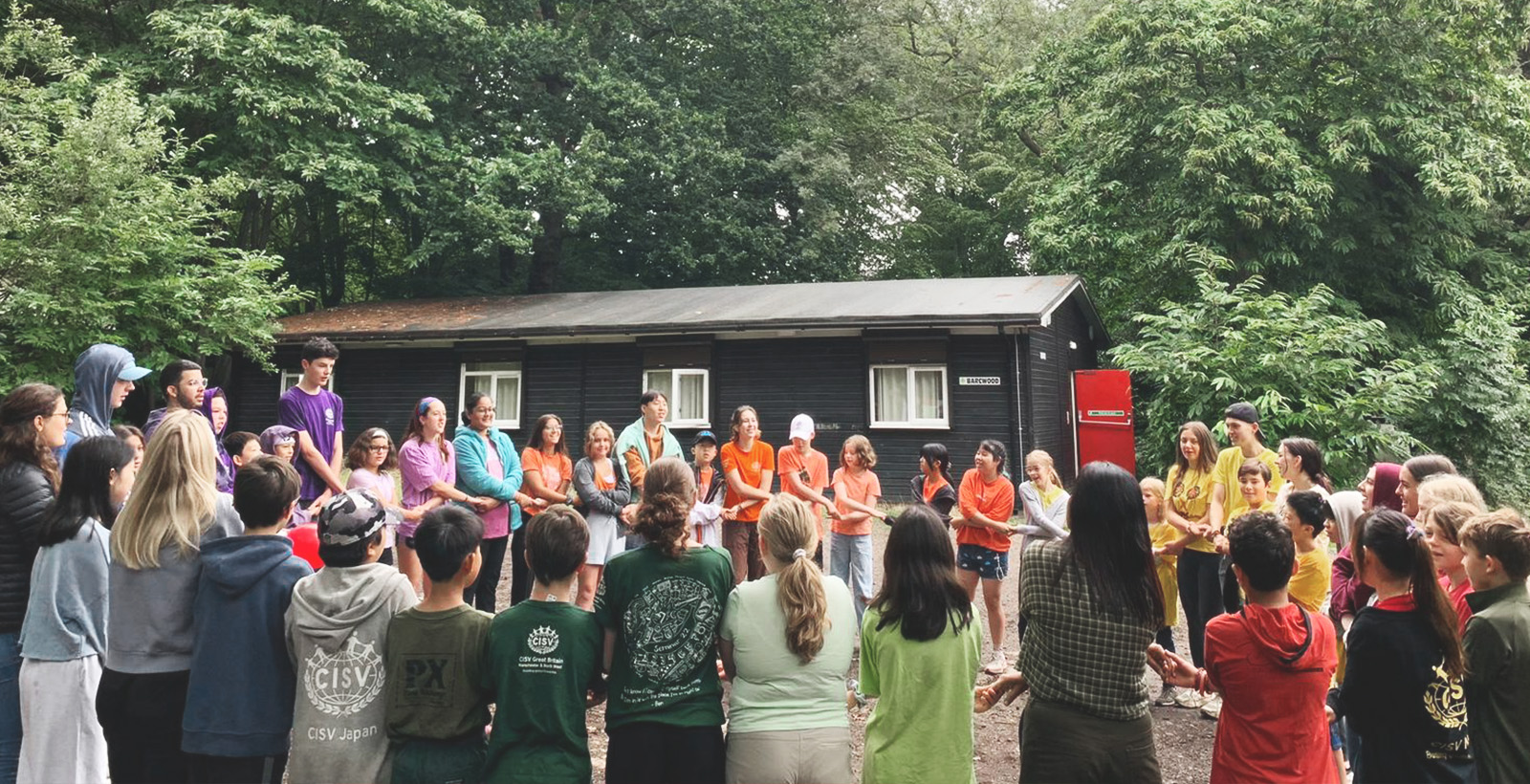 Village Teilnehmer stehen im Kreis und singen