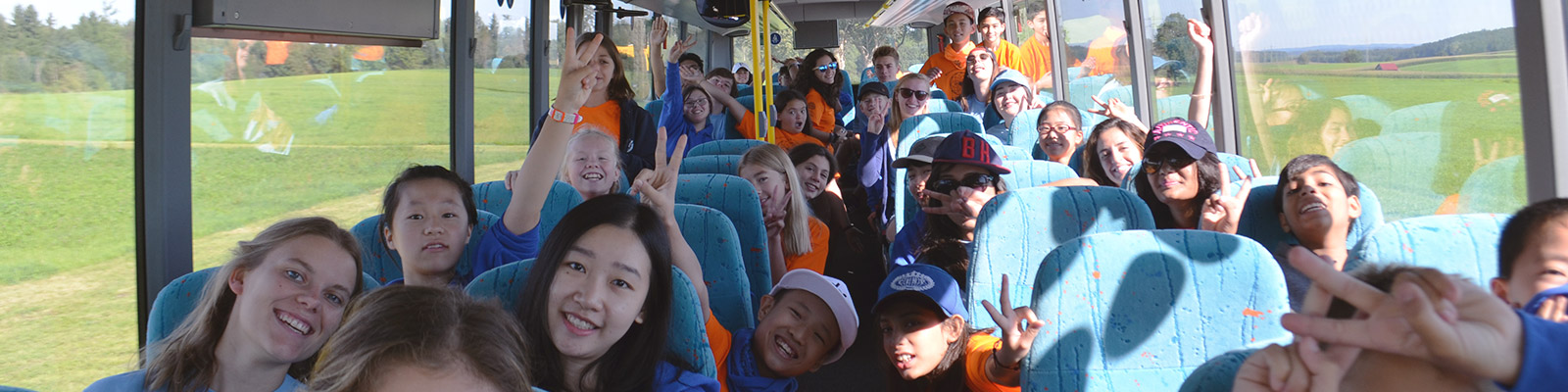 Glückliche Kinder und Jugendliche auf einem Ausflug im Bus